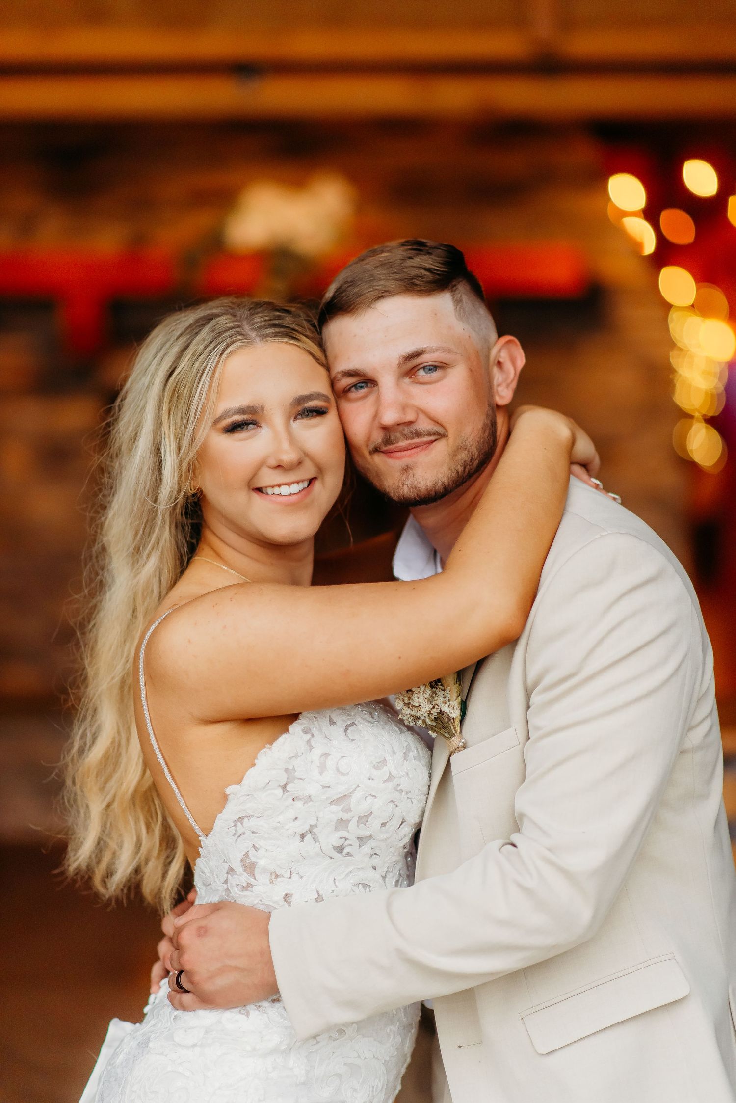 A romantic wedding photo series showing a couple dancing and embracing in a warmly lit indoor venue.