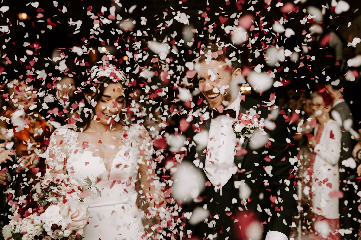 Pink and white confetti falling against a dark background in a celebratory display.