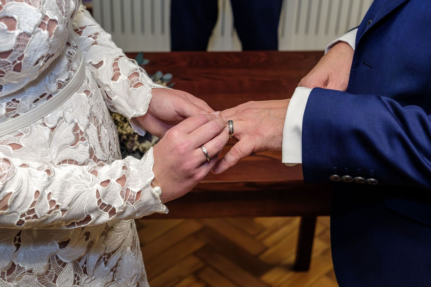 Close-up view of hands exchanging rings during a wedding ceremony.