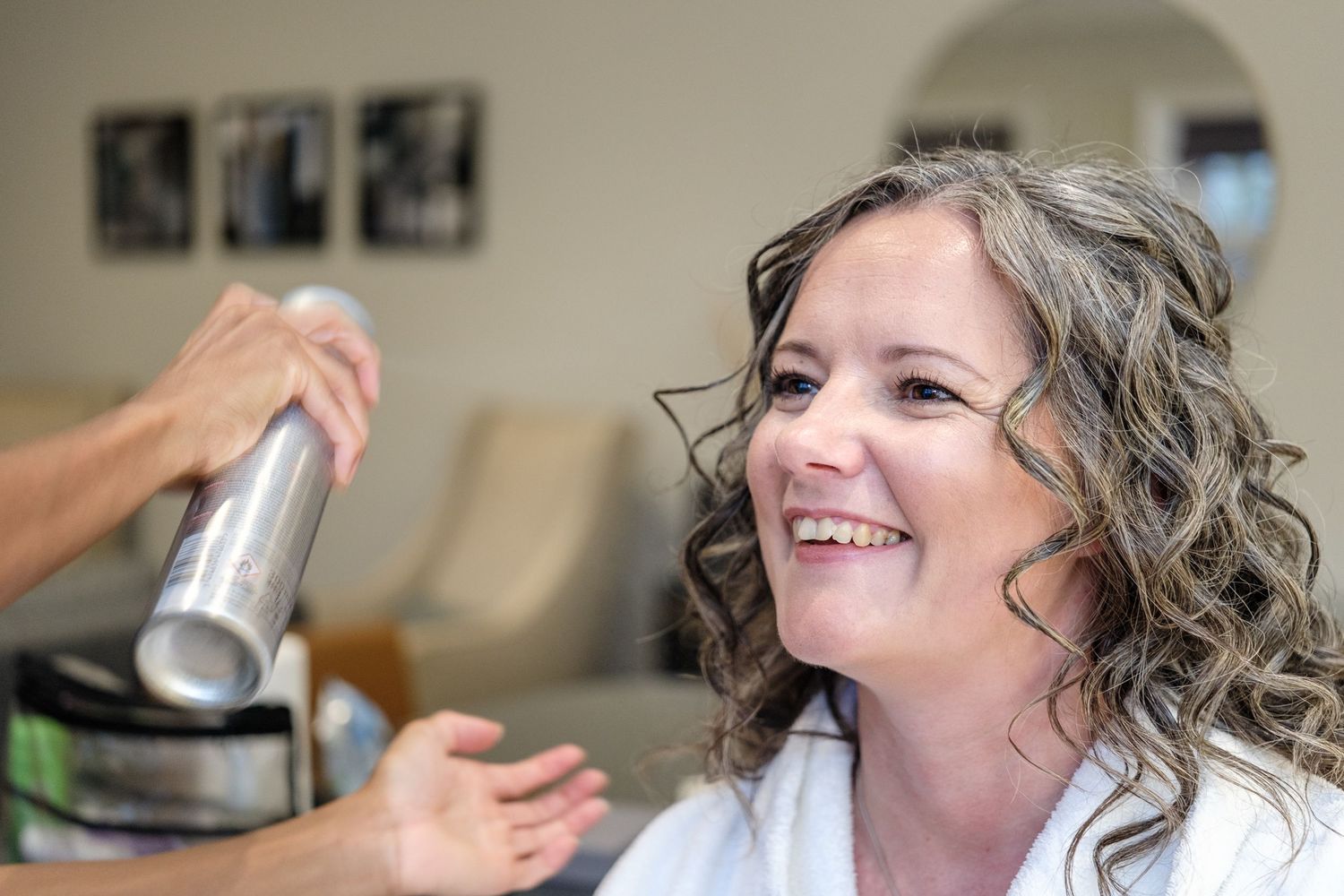 A series of photos showing someone getting their hair styled and curled in a salon setting.