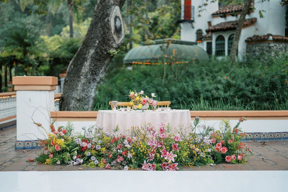 A panoramic view of a garden wall with colorful flowers and trees creating a serene outdoor setting.