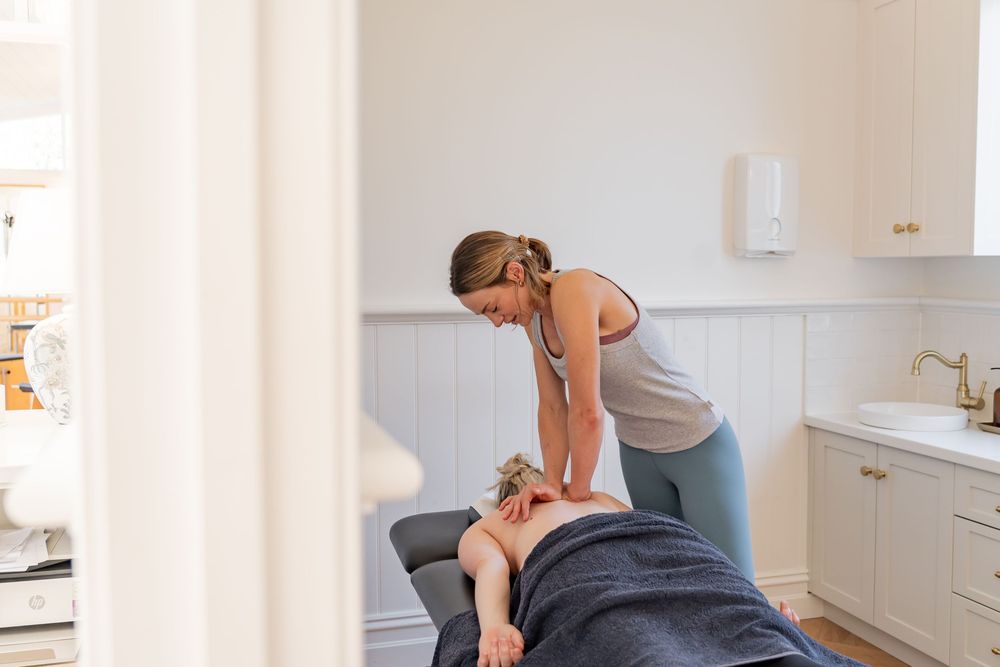 Instructor demonstrating proper form and technique during a private Pilates reformer session.