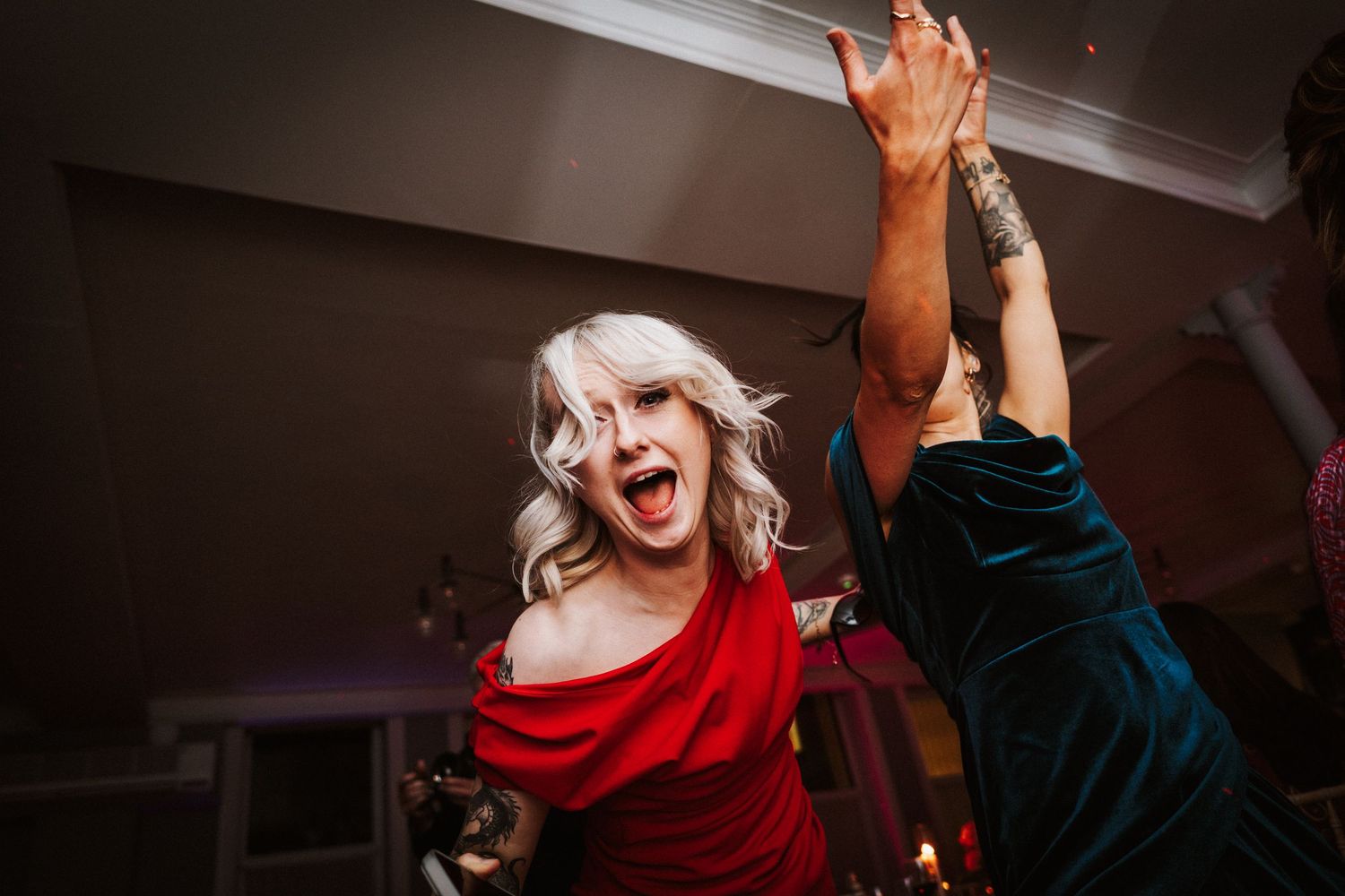 Energetic dance party at a wedding reception with guests in formal attire.