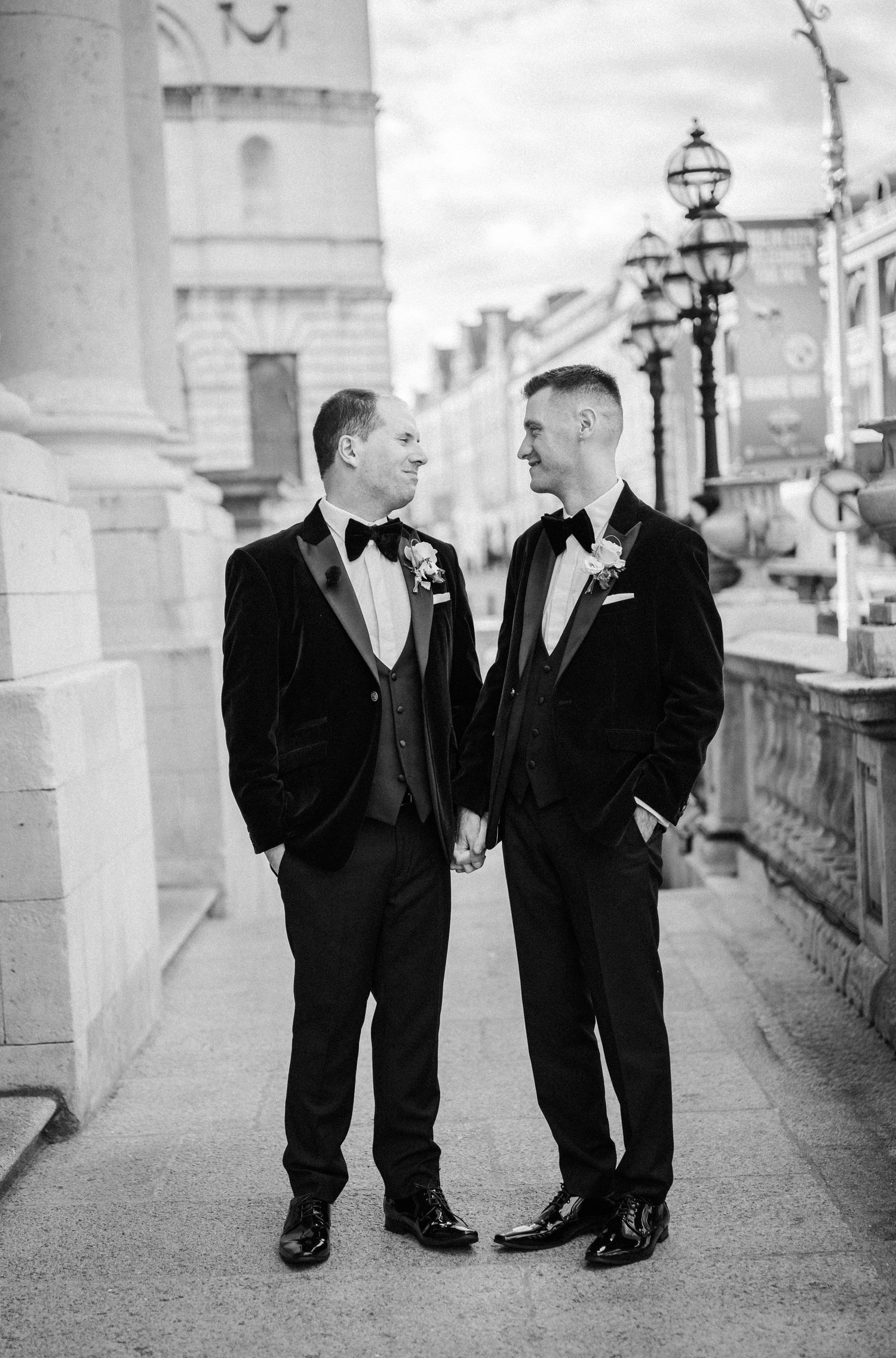 Black and white photo series of two people in formal attire sharing candid moments along a columned walkway.