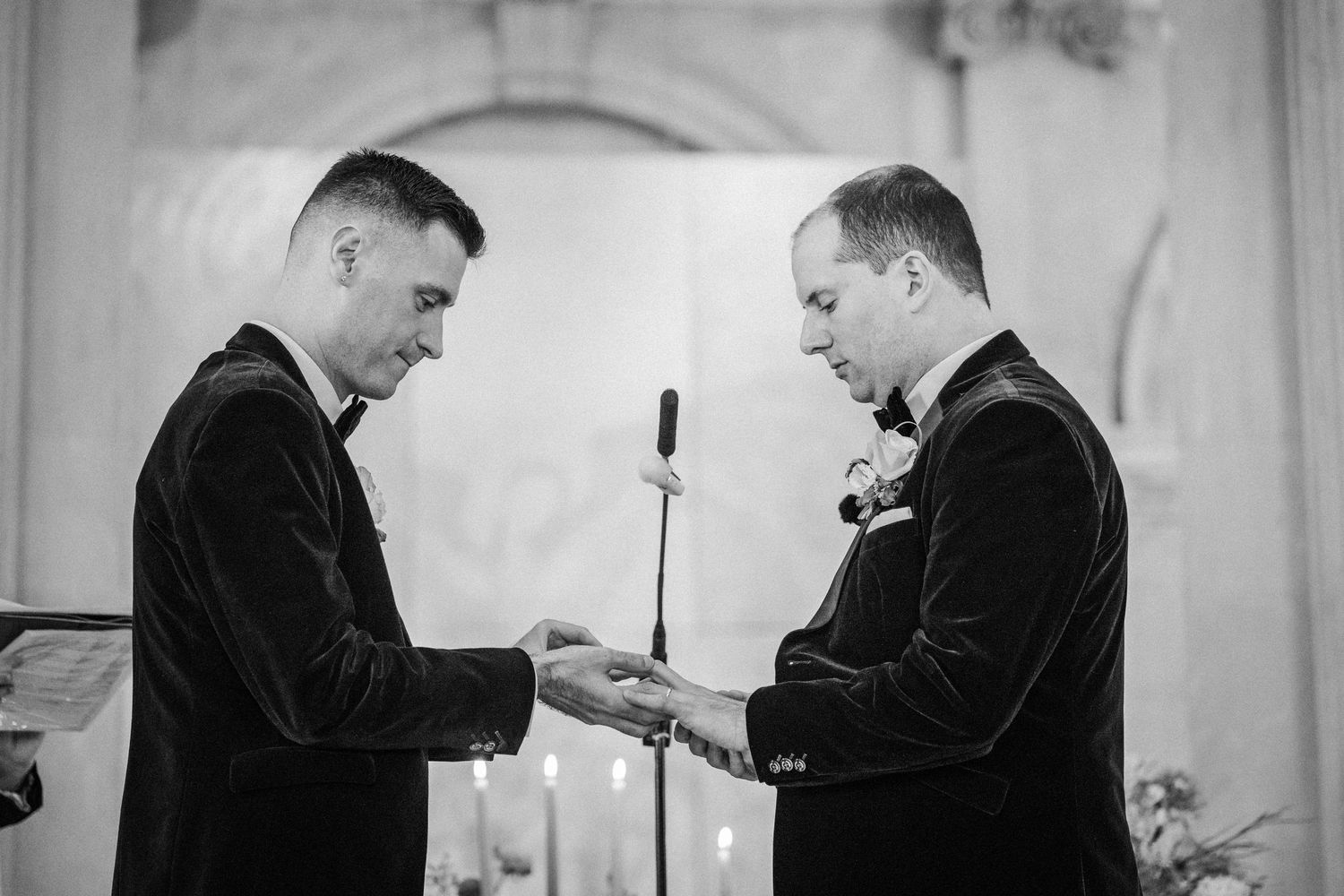 Two people in suits examining a document together in a professional setting.