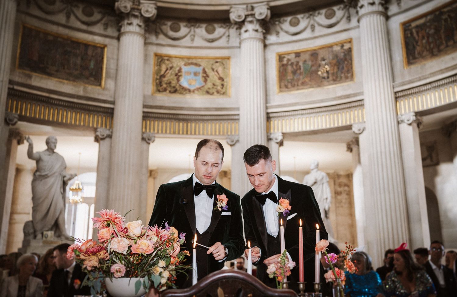 Wedding reception setup in a grand hall with classical columns and decorative ceiling details.