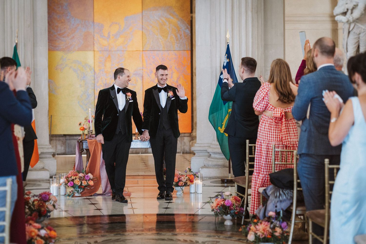 Wedding processional in elegant venue with yellow walls and classical white columns.