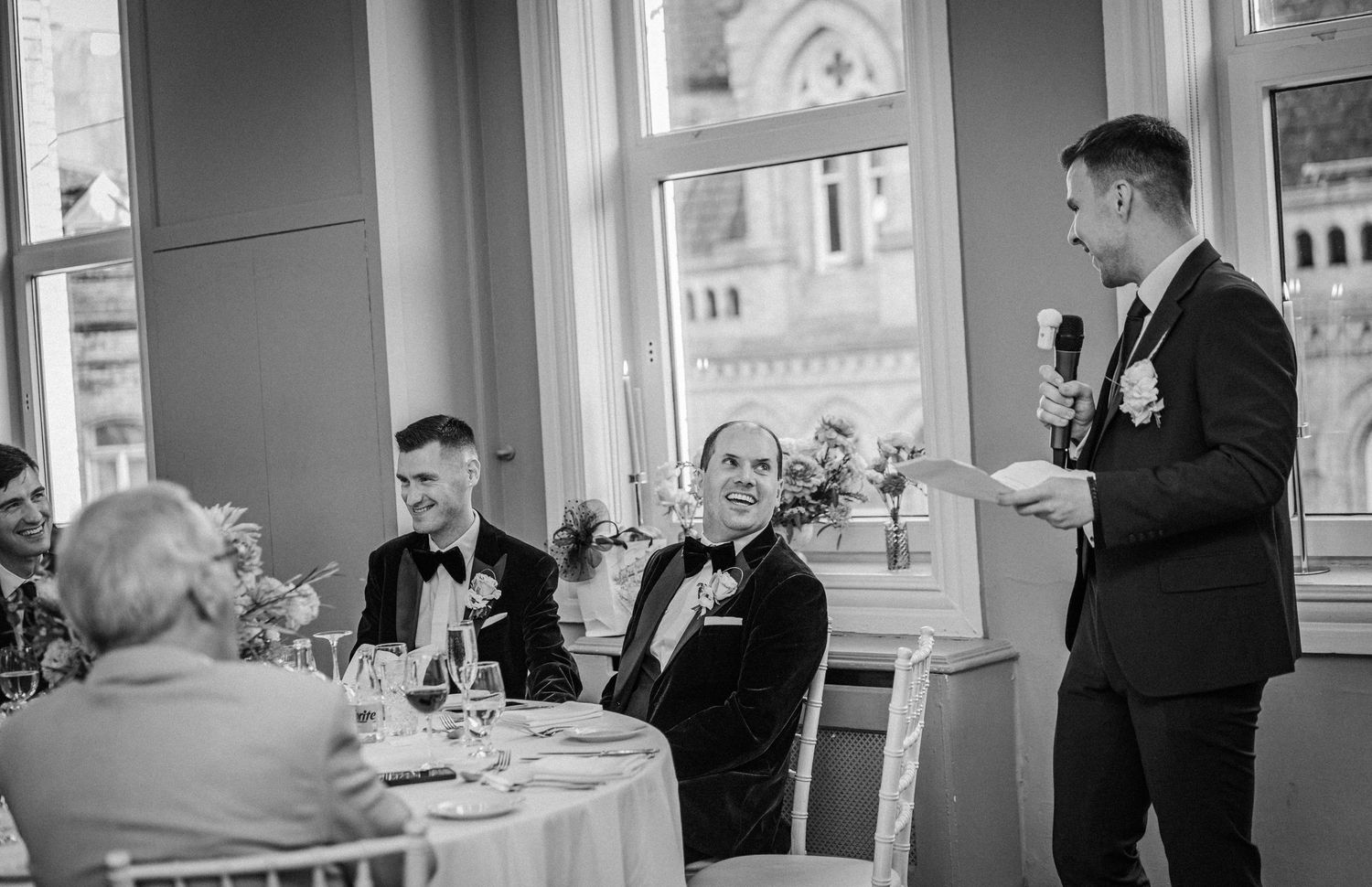 Black and white photo series showing elegant wedding reception moments at a formal dining venue.