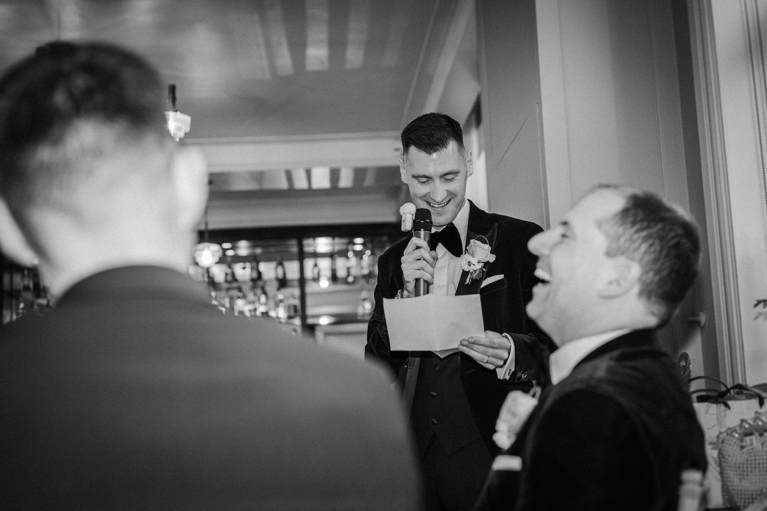 Wedding guests engaged in conversation during an indoor reception celebration.