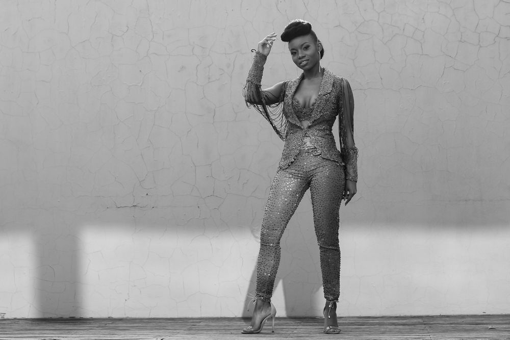 A black and white photograph of a teenage girl in a pant suit going to her matric dance.