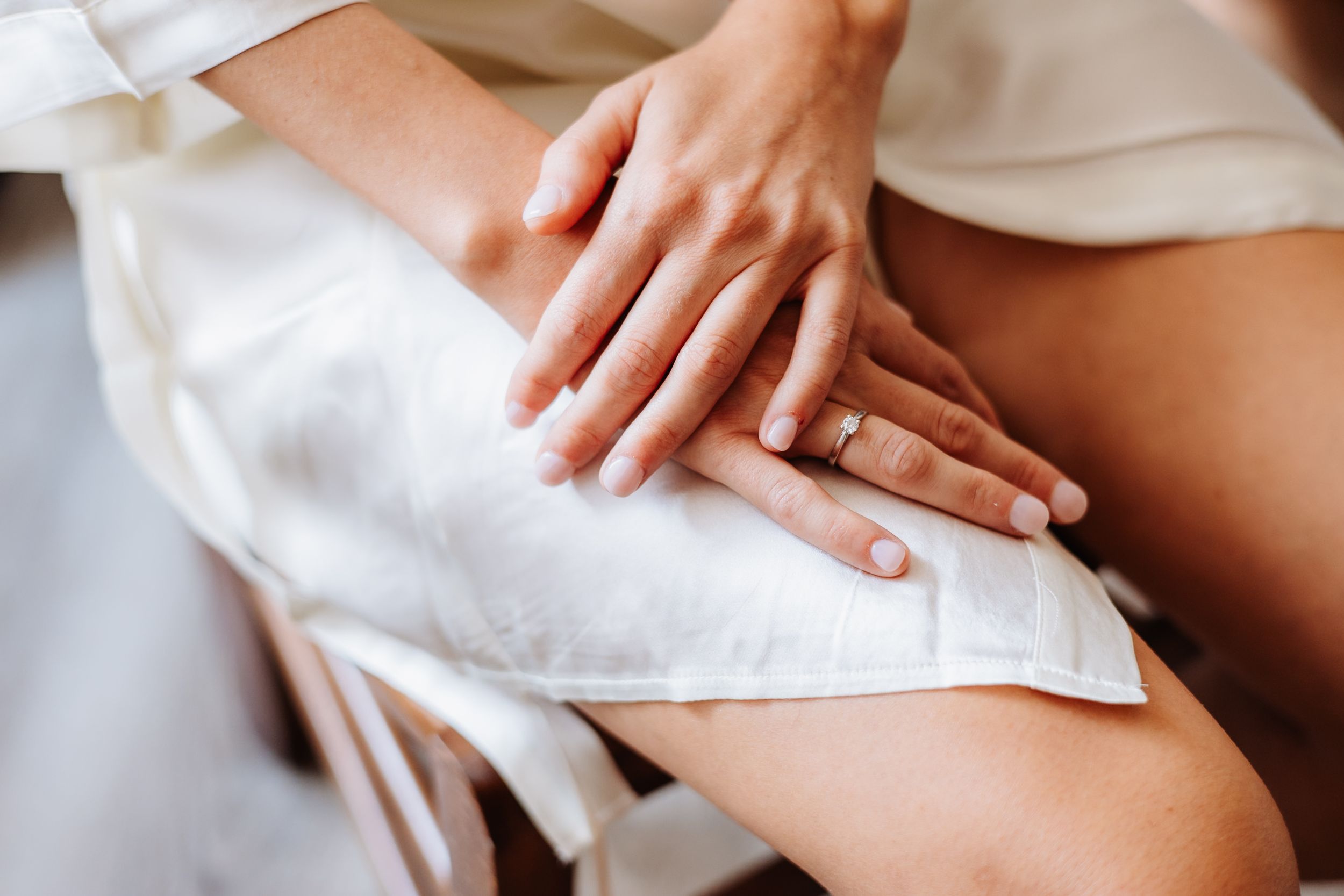 Close-up of hands performing a massage therapy treatment on a person's shoulder and back.