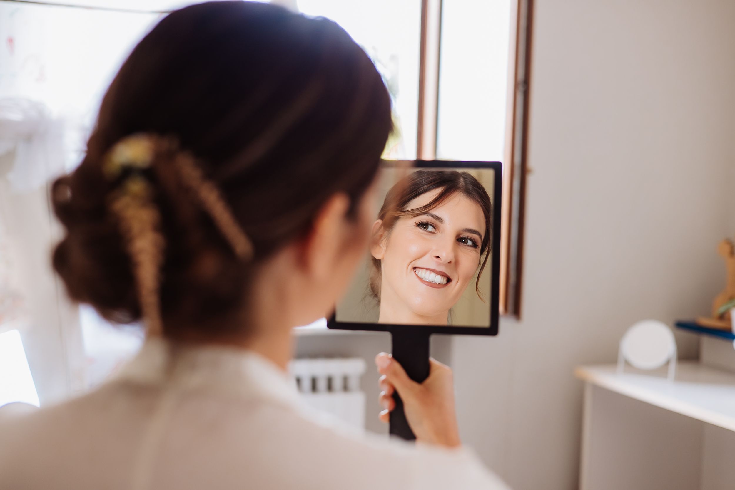 A makeup artist applies cosmetics to a client's face during a professional beauty session.