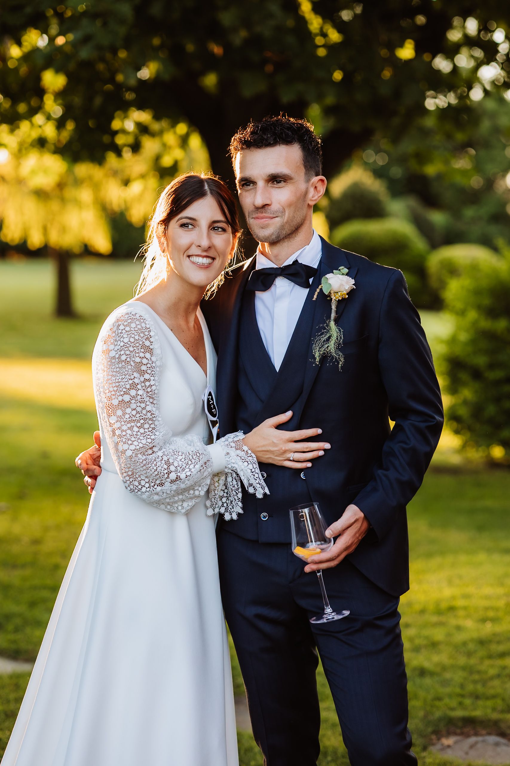 Newlywed couple shares intimate moments in a garden setting during golden hour sunset.