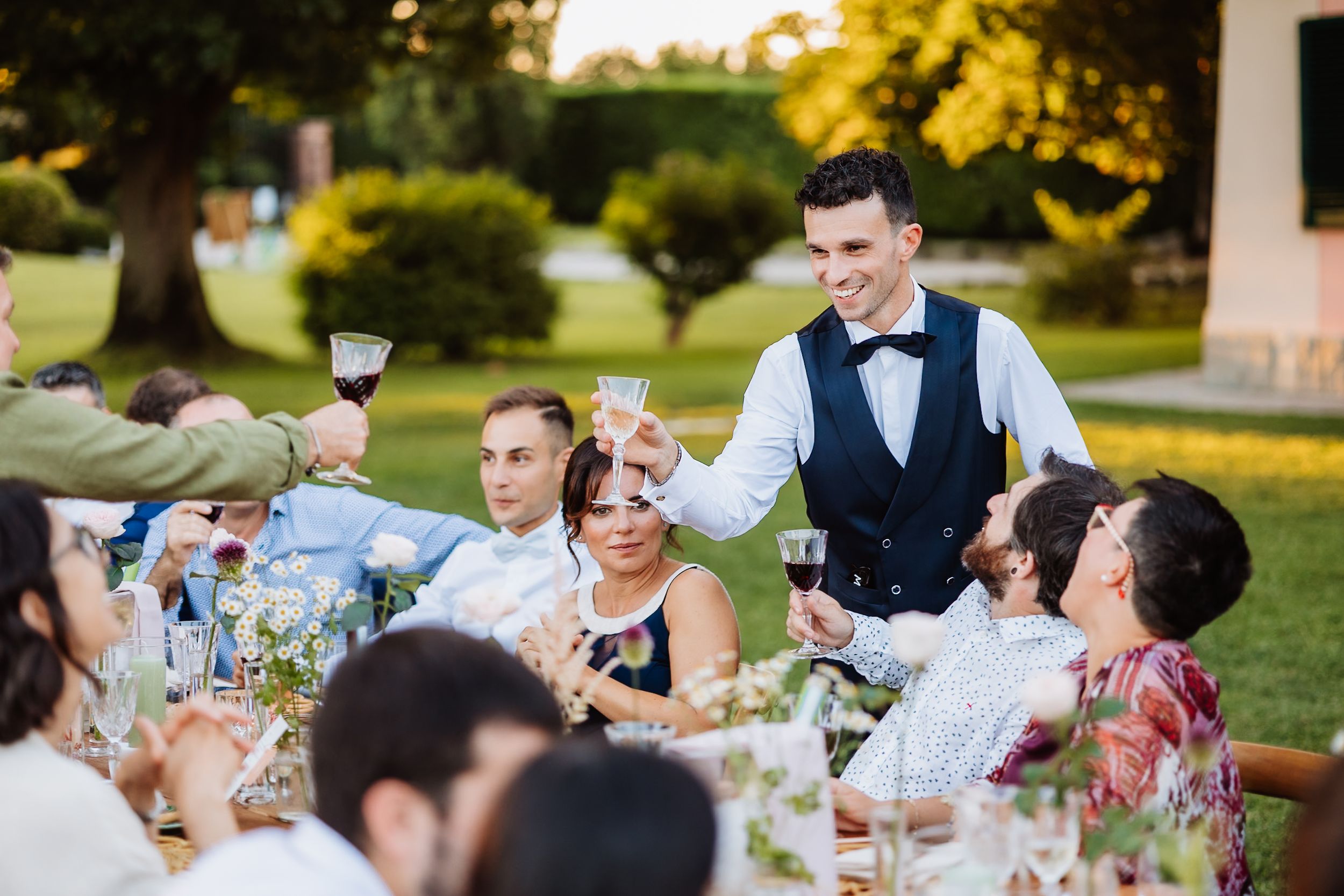 Wedding guests enjoying dinner and conversation at an outdoor reception.