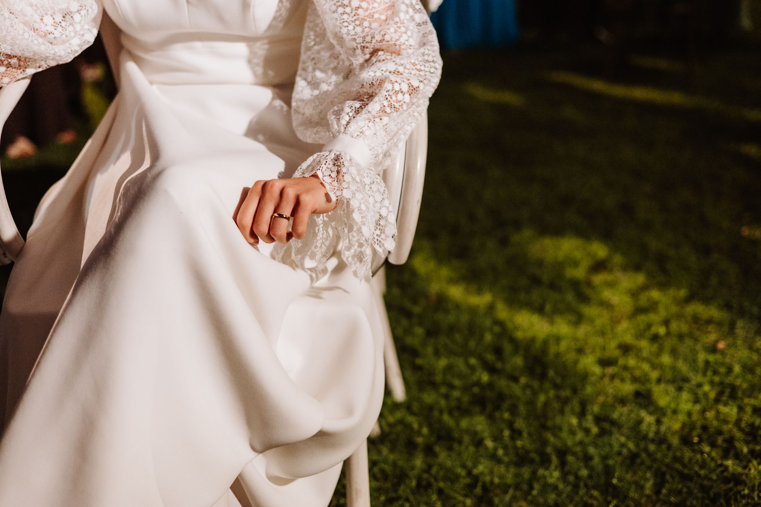 Close-up details of an elegant white lace wedding dress with intricate floral patterns and delicate beadwork.