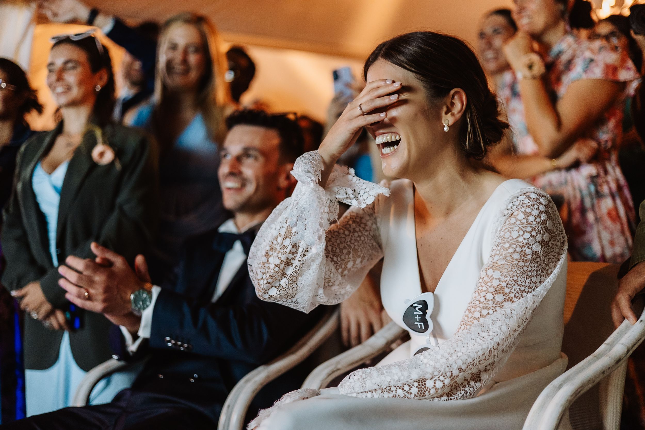 Wedding celebration captures joyful reactions and laughter during an emotional moment.