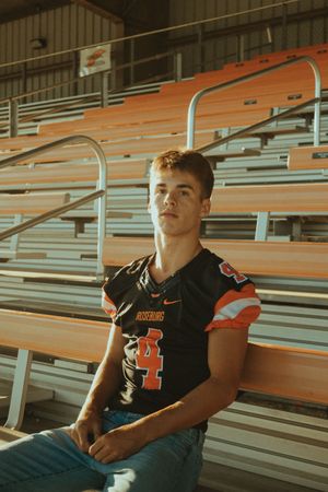 Player wearing black jersey number 41 sitting in orange stadium bleachers.