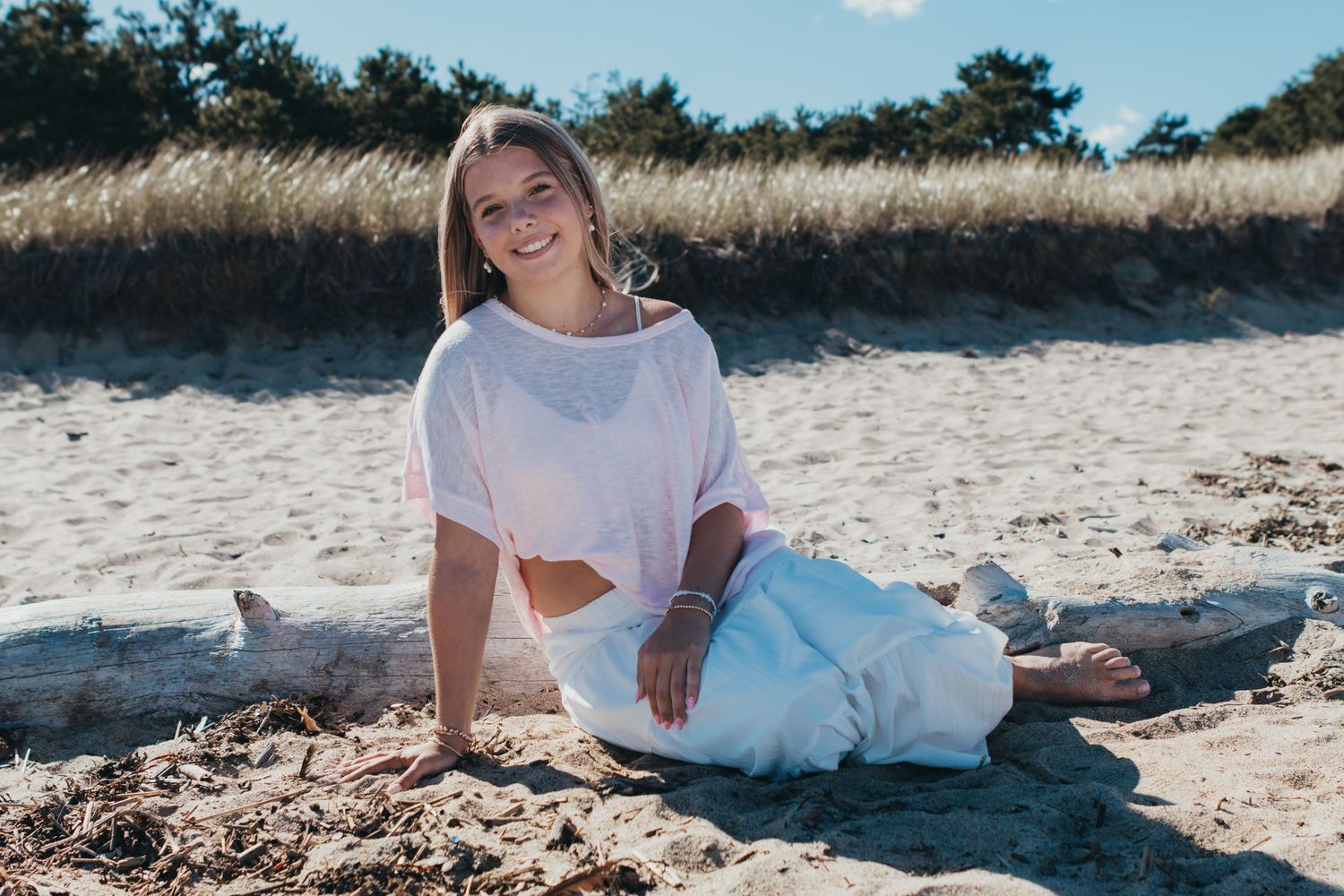 Relaxed beach portrait session with soft lighting and sandy backdrop.