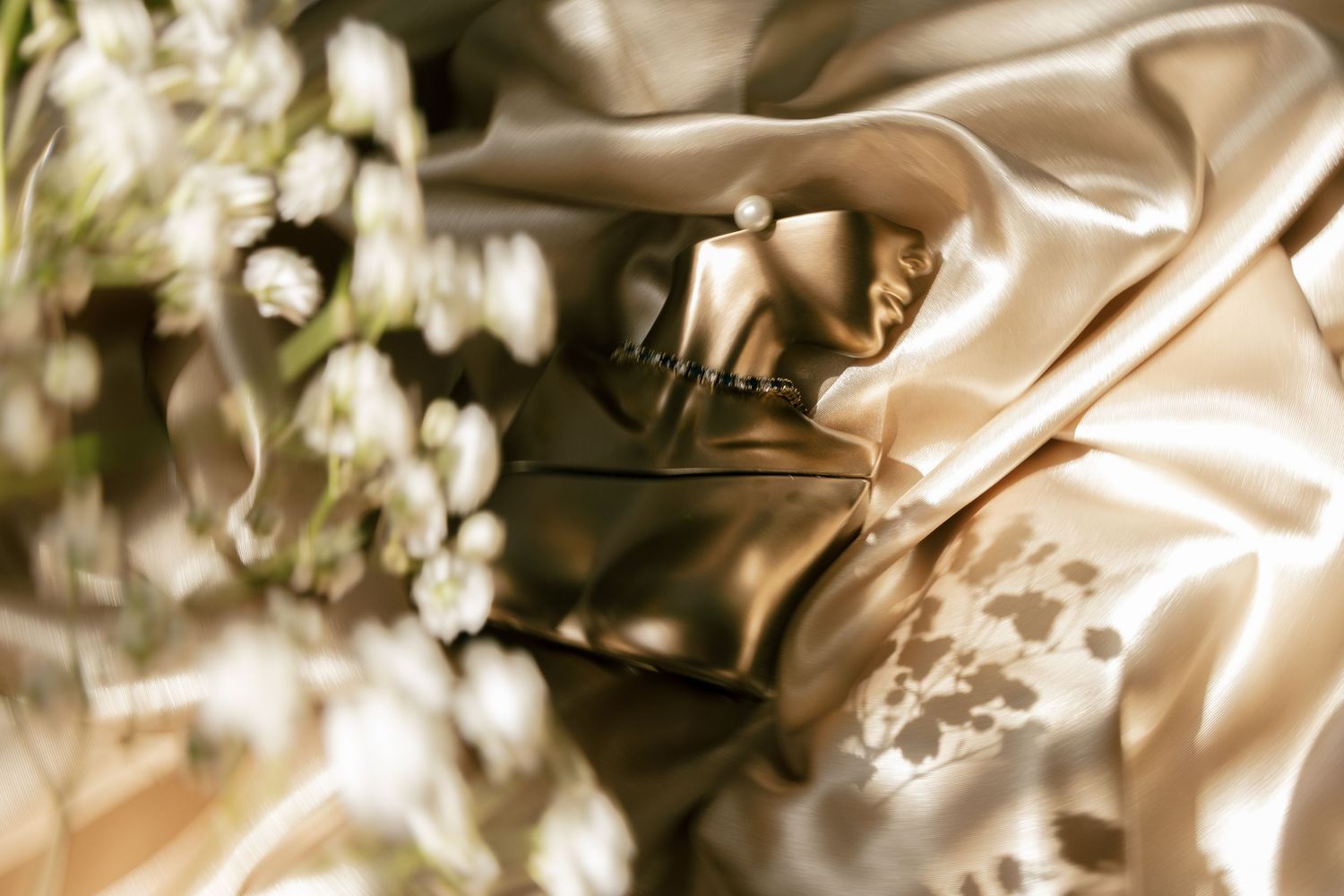 Close-up of delicate champagne satin fabric with soft lighting and bokeh effects.