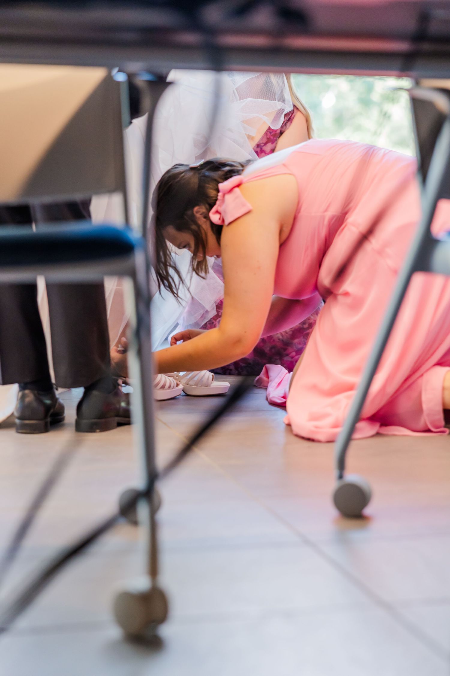 A person in pink attire performing a low bow or deep curtsy on a stage or dance floor.