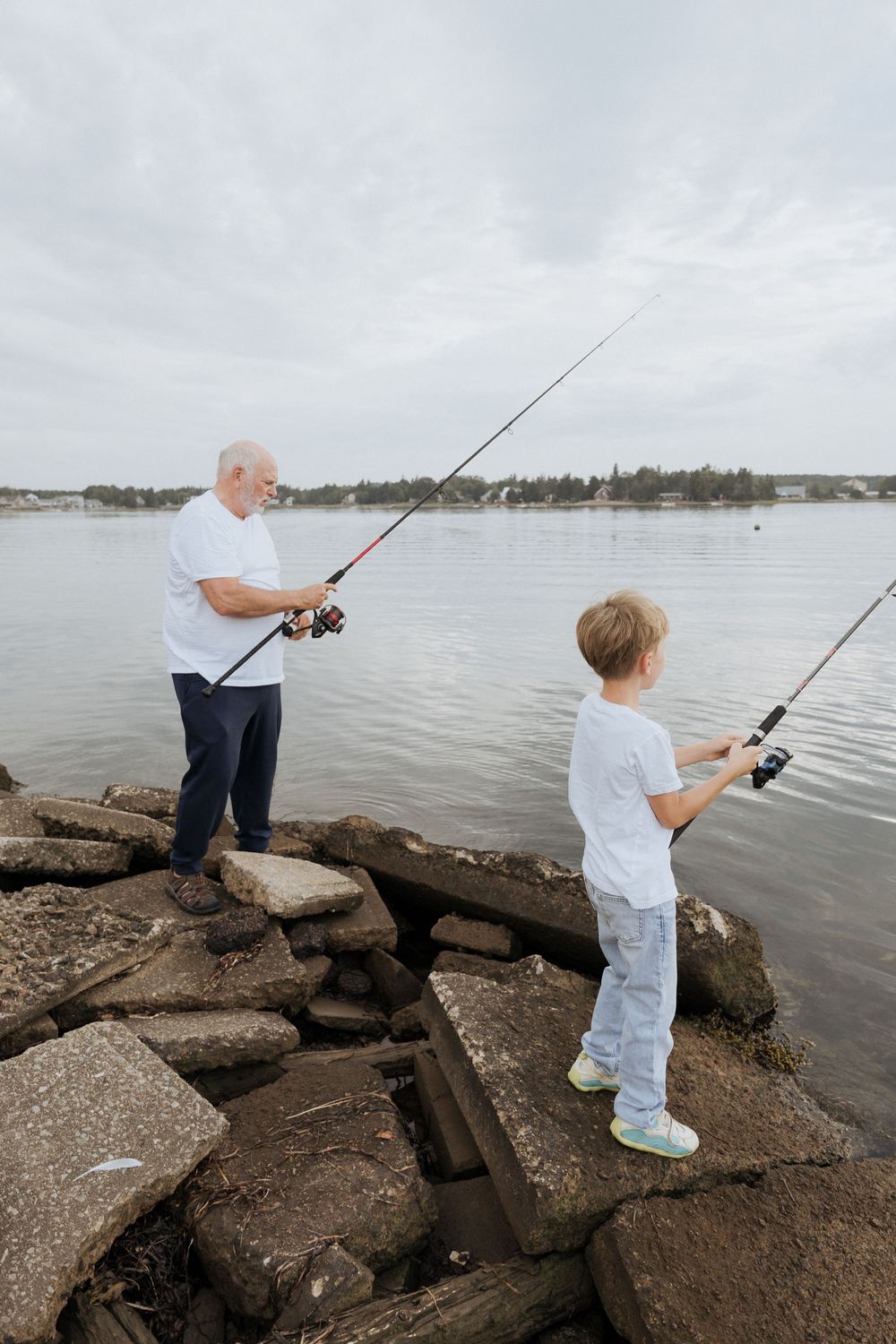 boy and his grandpa fishing during fun candid photography session, authentic moment photography Moncton New Brunswick photographer