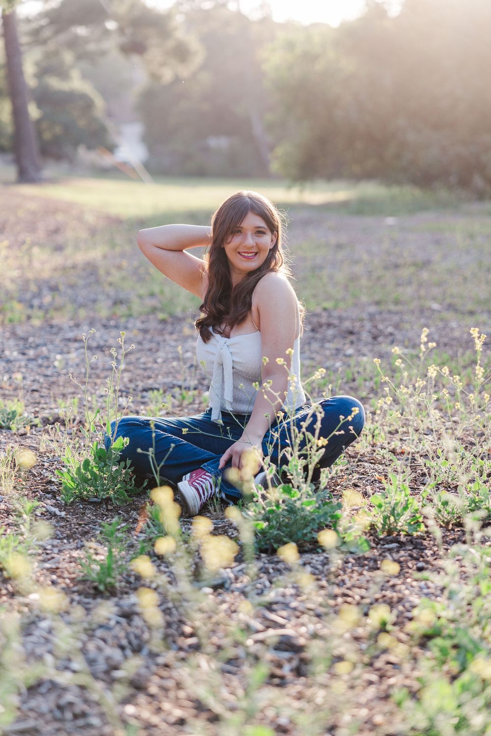 A person sits in a wildflower field during golden hour.