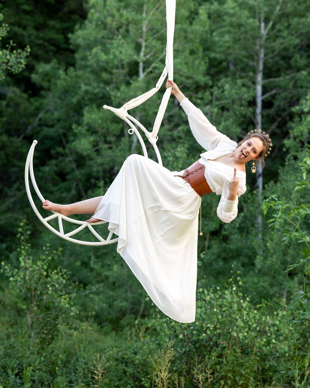 Aerialist performing on a white moon lyra — fine art aerial moon photography blending strength, balance, and celestial beauty.