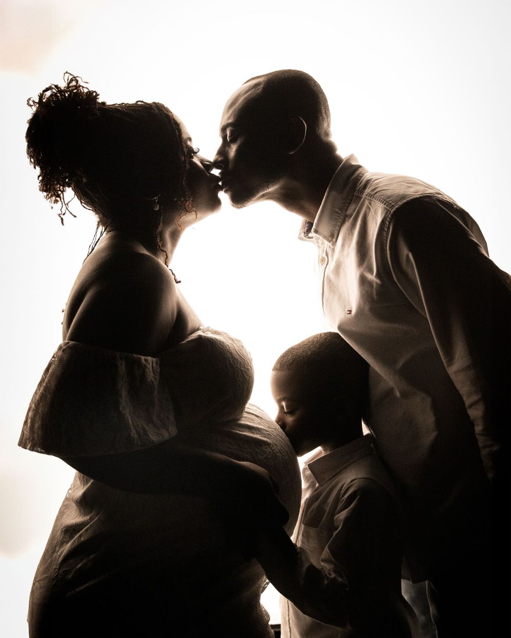 Silhouetted figures in white background depicting stages of pregnancy and early parenthood in tender moments.