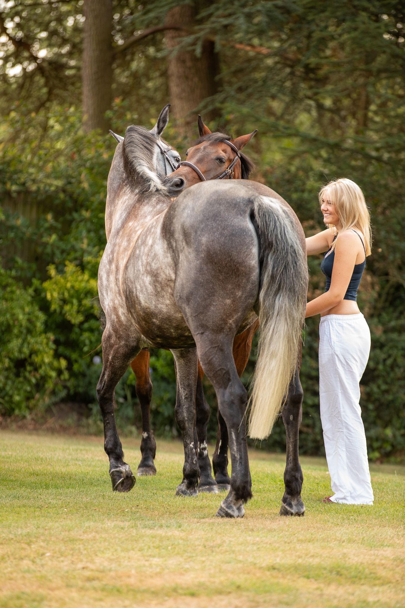 Young equestrian poses with palomino pony in a series of natural outdoor portraits showing their special bond.