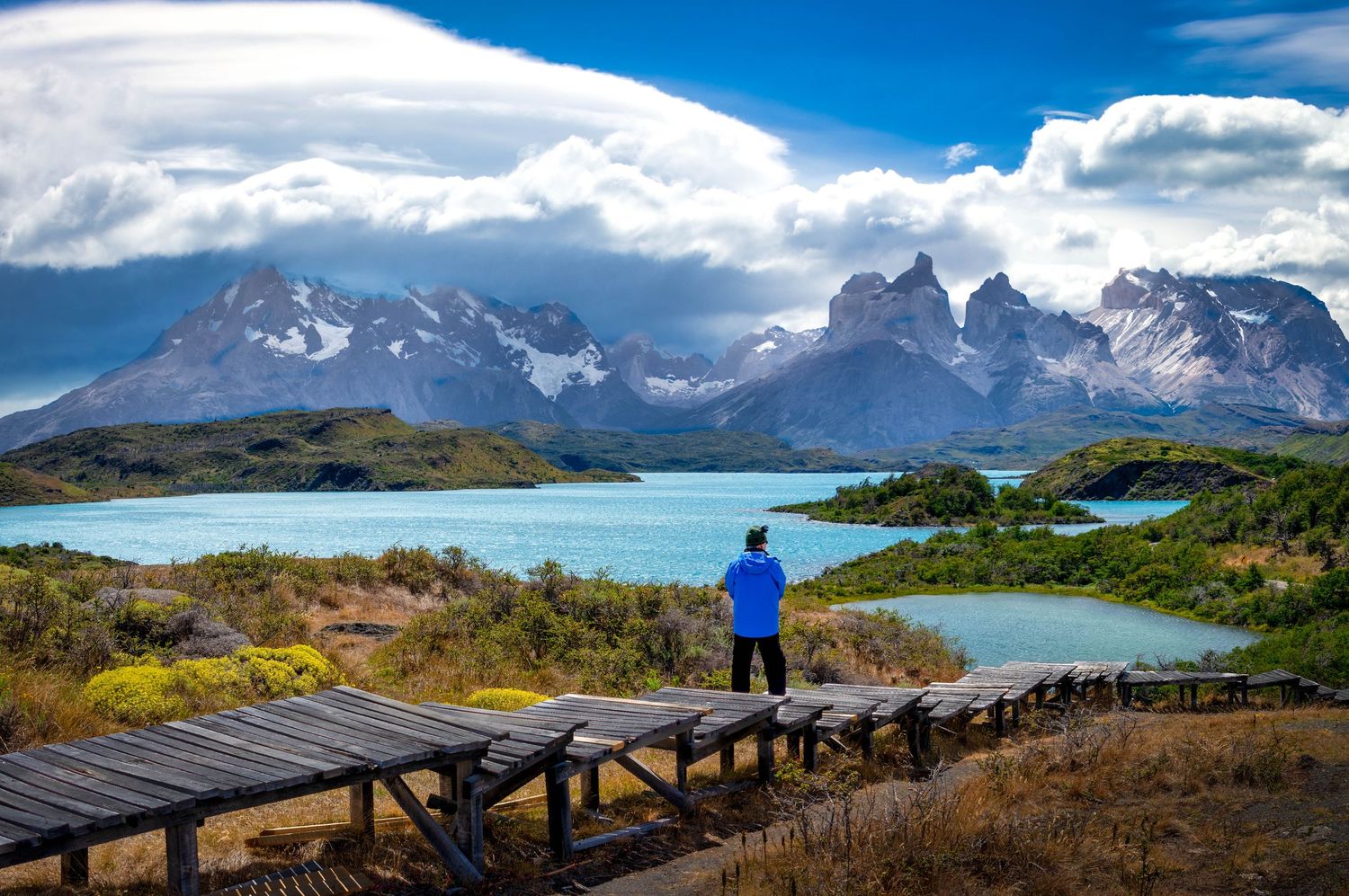 A panoramic view of Torres del Paine National Park in Chile showcasing dramatic mountain peaks and turquoise lakes.