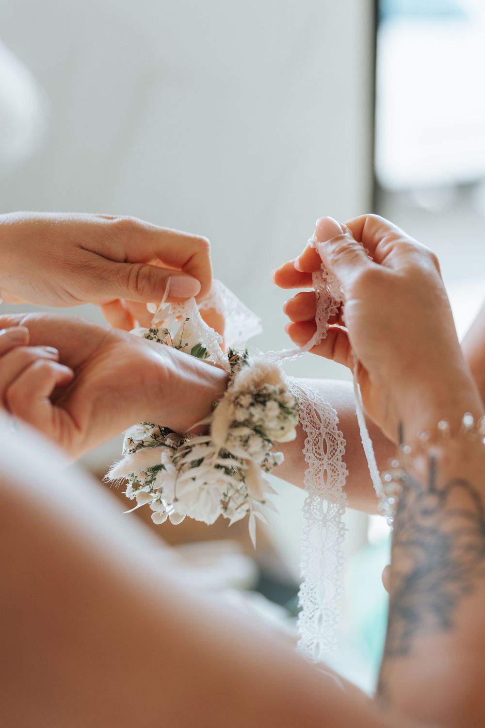 Hands gently pull apart soft, delicate white cotton candy strands in a close-up sequence of photos.