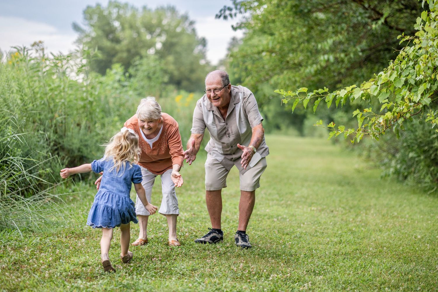Springfield, IL Photographer captures a girl running to her grandparents in a grass clearing at Centennial Park, Springfield, IL