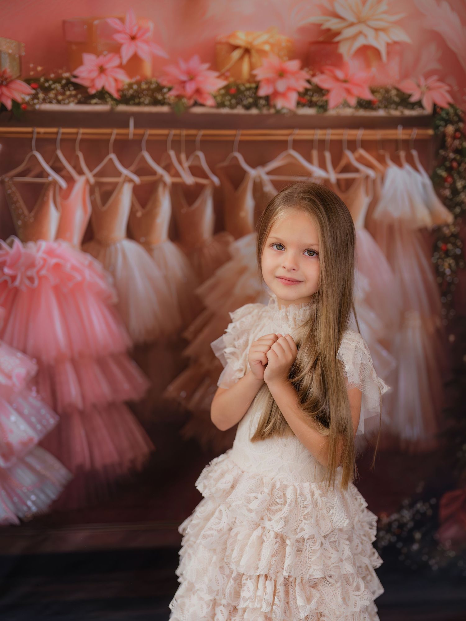 A collection of pink and white tulle dresses hanging in a boutique with soft lighting and romantic ambiance.