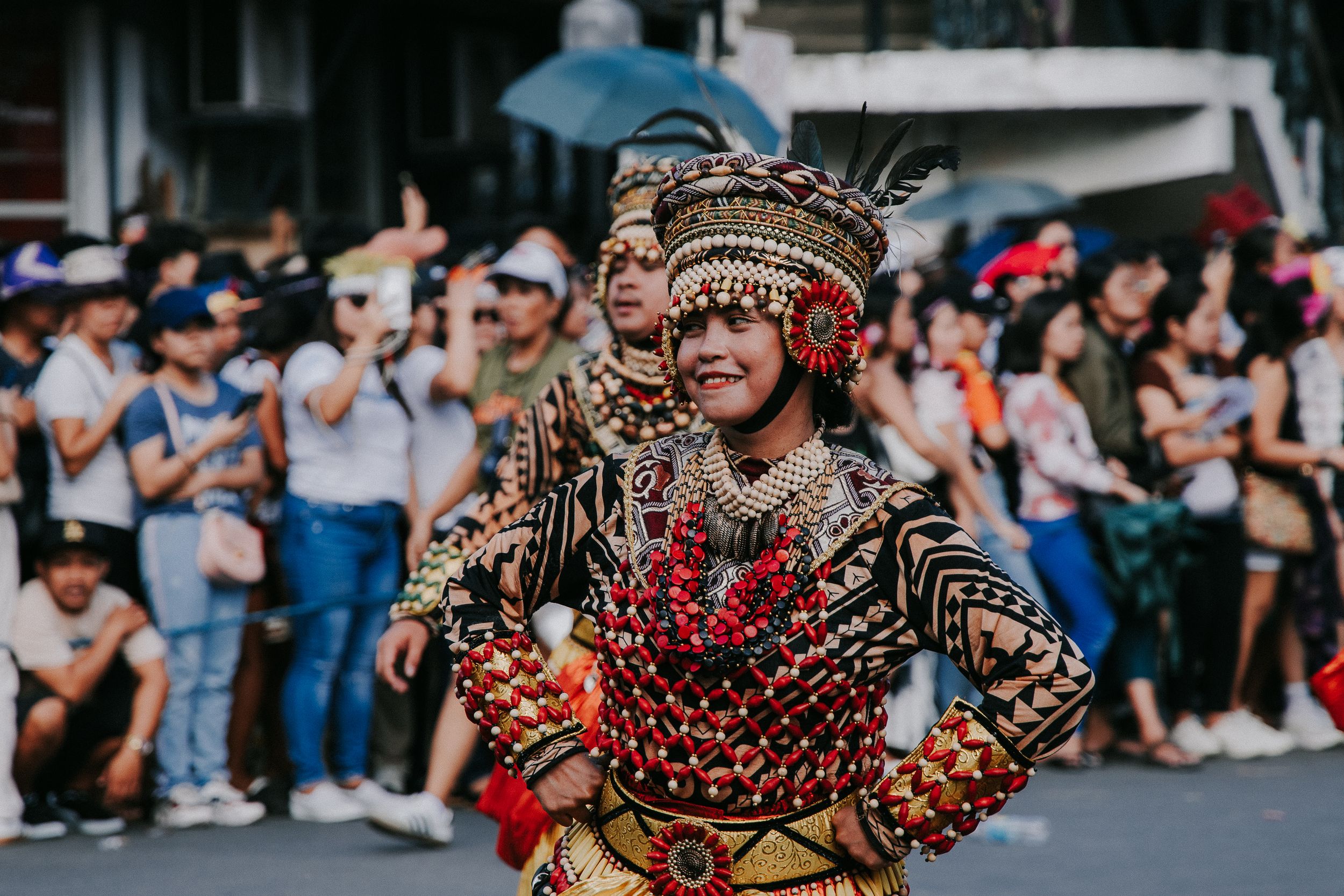 Festival dancers in coordinated costumes performing synchronized movements during a street parade.