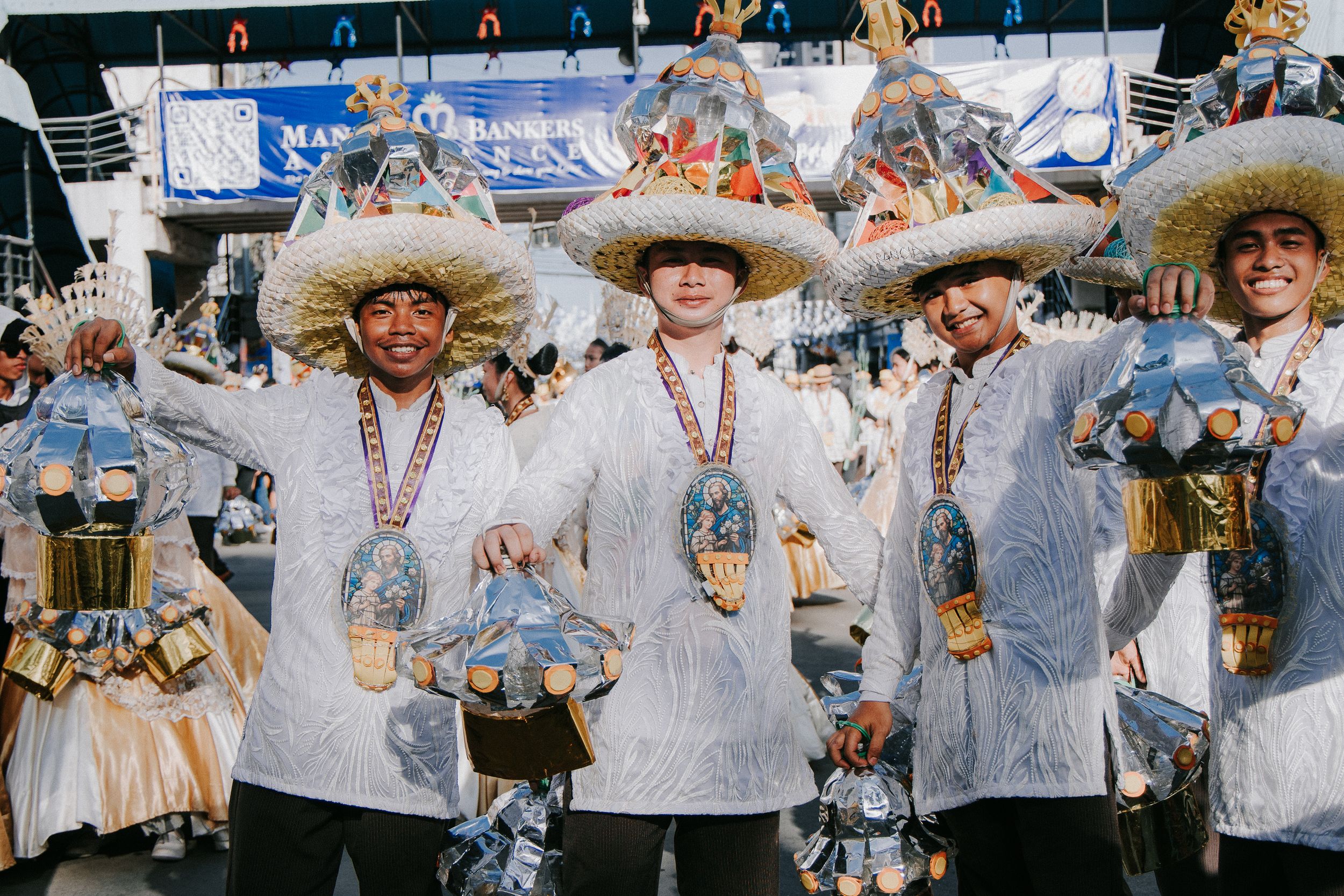 Group of festival participants in white traditional outfits lined up during a parade celebration.