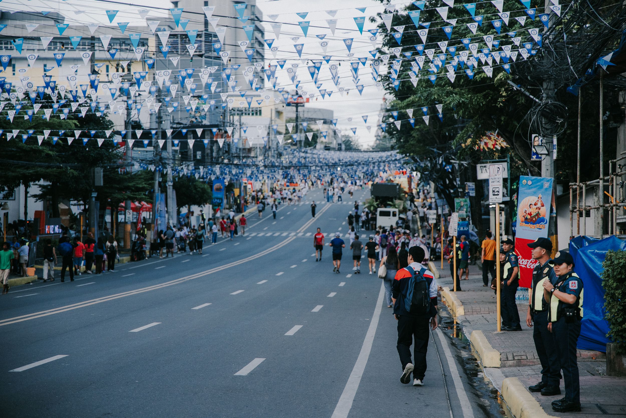 Aerial view of a crowded street festival with performers and spectators lining both sides.
