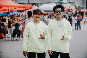 Group wearing matching cream-colored sweaters walking together at a festival.