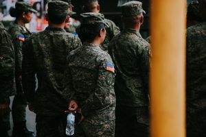 Row of uniformed personnel standing at attention during a formal ceremony.