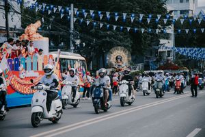 Street decorated with blue triangle banners and motorcycles during a festival.