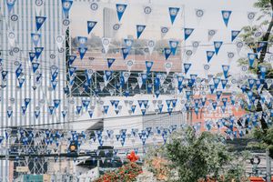 Blue and white triangle banners strung across street creating festive atmosphere.
