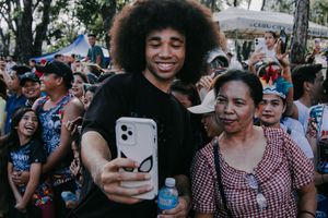 Festival attendees take selfies together during a lively outdoor celebration.