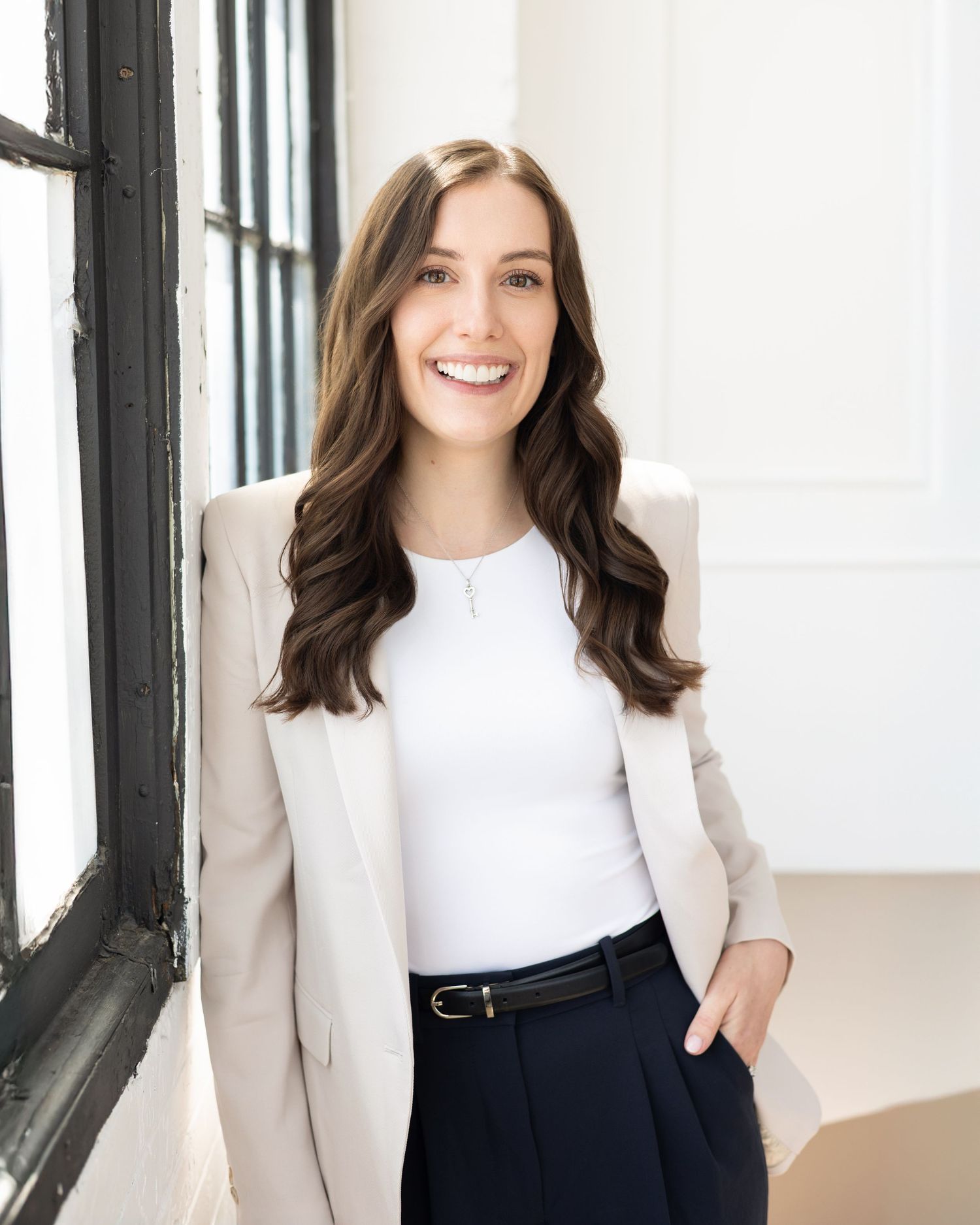 London realtor branding headshot of Sachia Pepler, brown hair wearing white shirt and cream blazer with dark blue pants and black belt