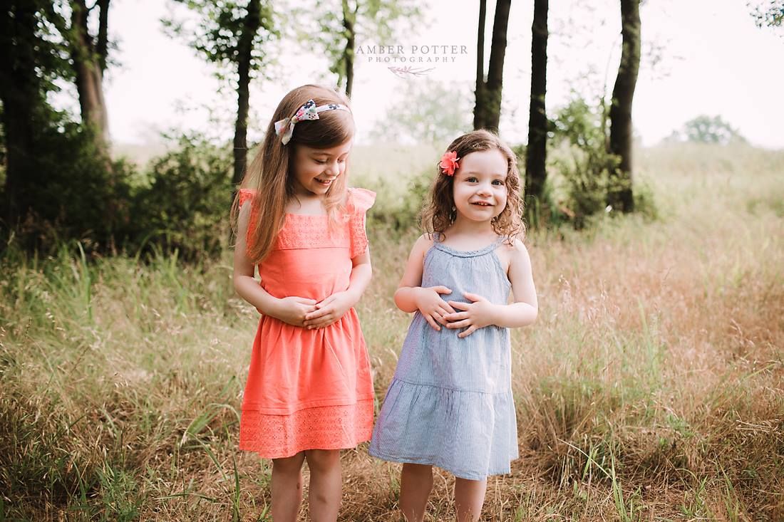 Family laughing together in field during outdoor photo session in Springfield MO.