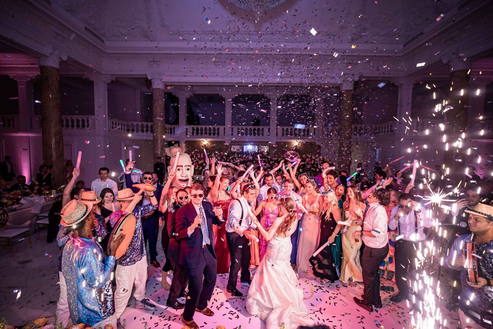 Wedding celebration reaches peak excitement with confetti and sparklers illuminating the dance floor.