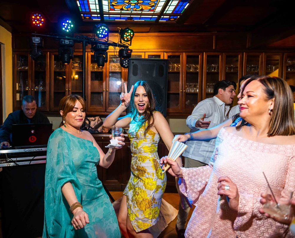 Lively wedding reception with colorful lights and dancing party guests.