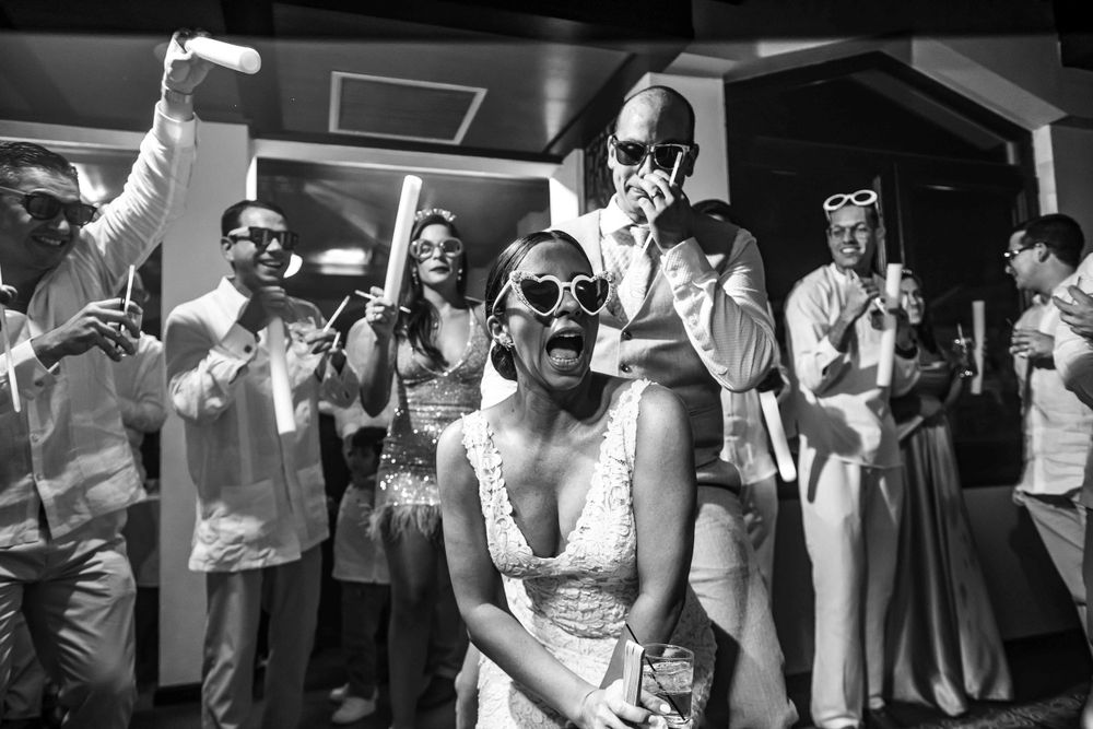 Black and white photo of wedding celebration with joyful guests dancing.