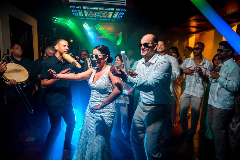 Wedding party dancing and celebrating under vibrant disco lights.
