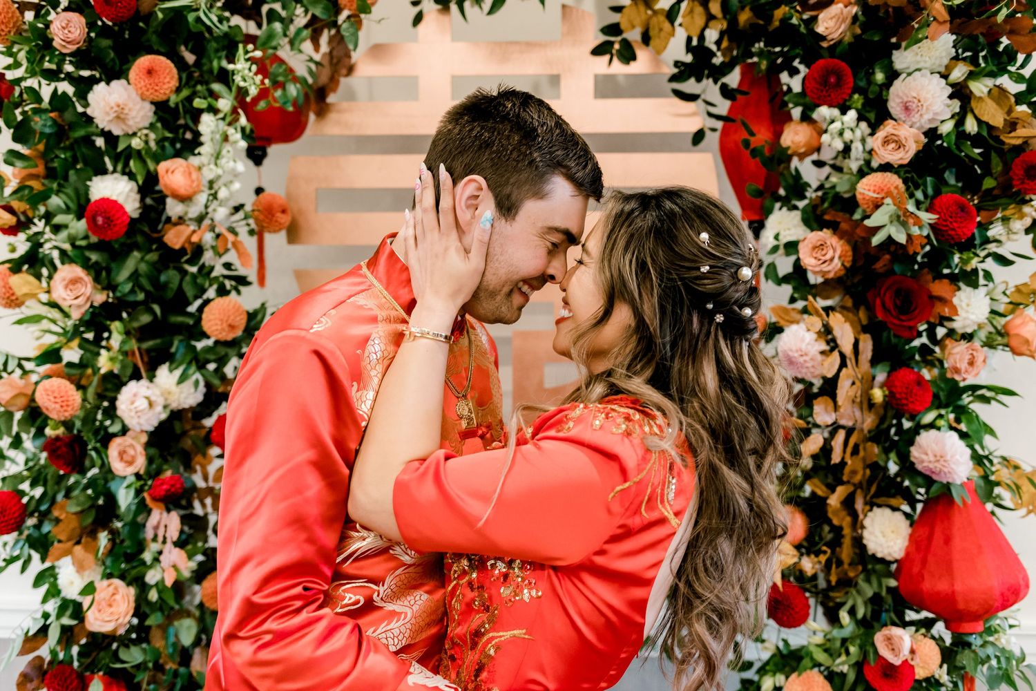 Romantic floral arch with red and pink blooms framing a special moment.