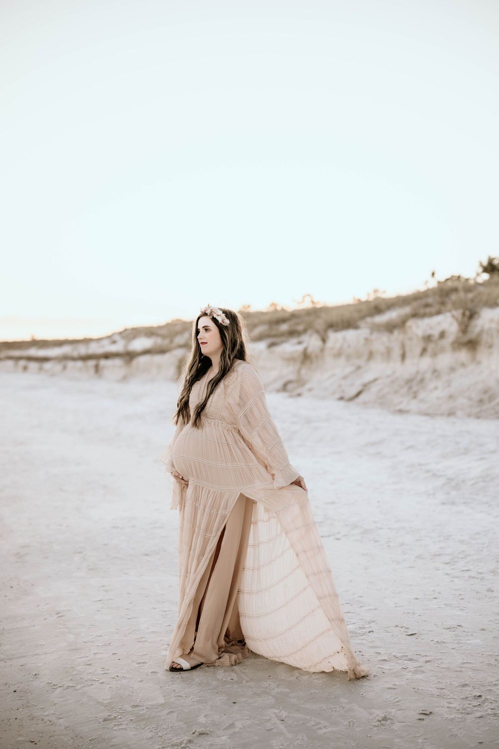 Panama City Beach photographer, family photos PCB, 30A beachside maternity portrait with flowing cream dress against sandy dunes.