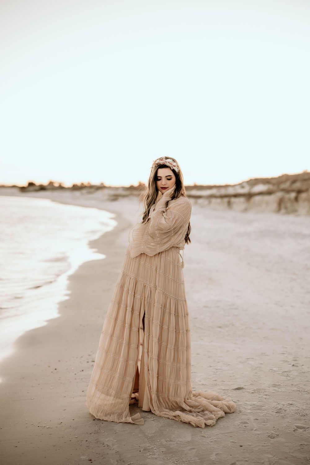 Panama City Beach photographer, dreamy beach photoshoot featuring an ethereal beige lace dress against sand dunes and ocean waves at sunset.